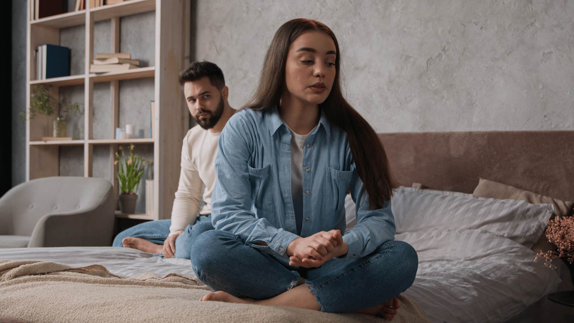 woman and man ignoring each other on bed