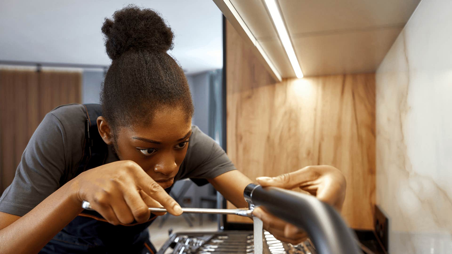 woman fixing a sink