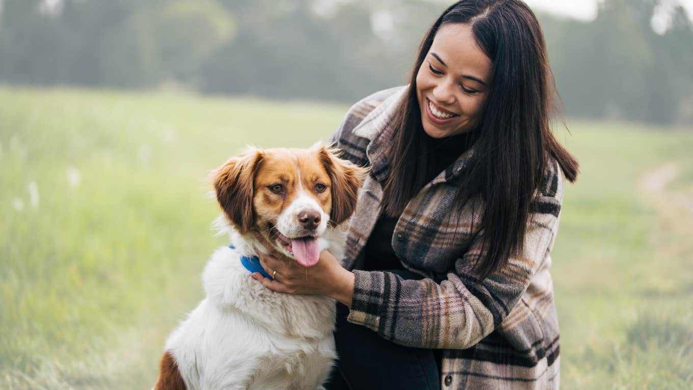 Woman claiming her dog and smiling. 