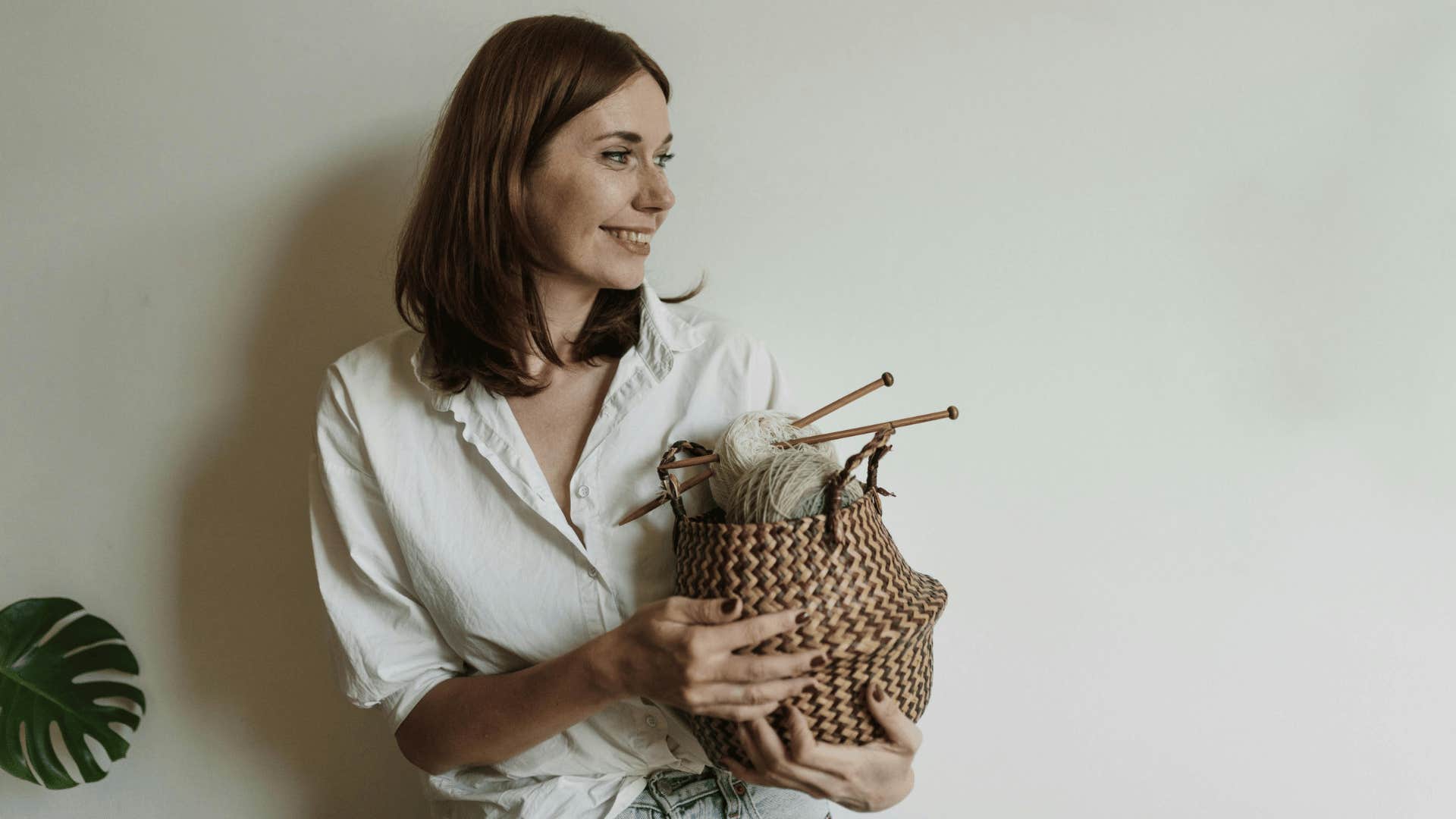 smiling woman holding basket of yarn