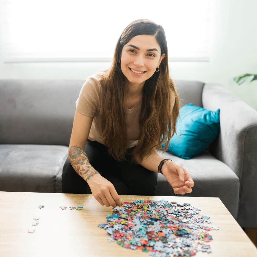 smiling young woman working on a puzzle