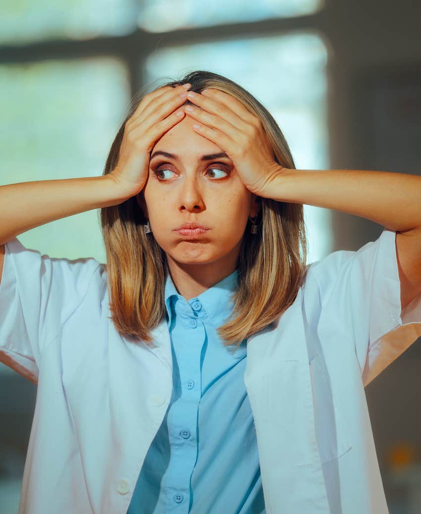 Frustrated woman puffs cheeks and holds head