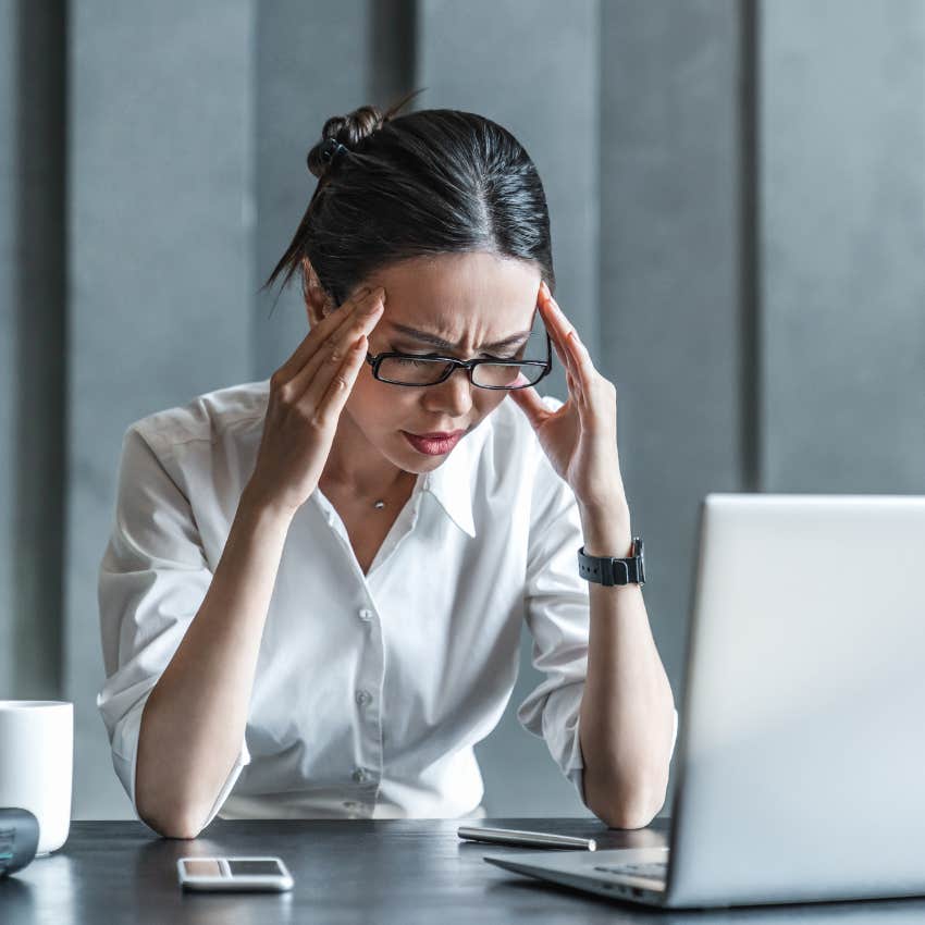 Stressed employee looking overwhelmed at work.