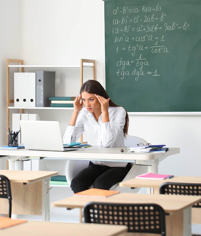 teacher rubbing temples feeling stressed