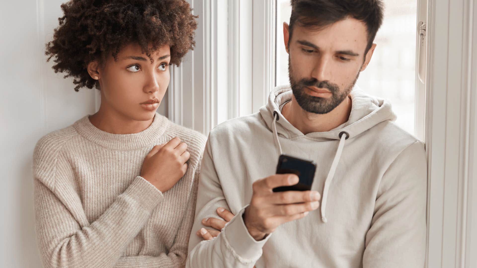 man playing on his phone ignoring woman