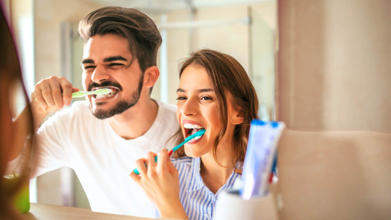 Couple brushing teeth together in bathroom