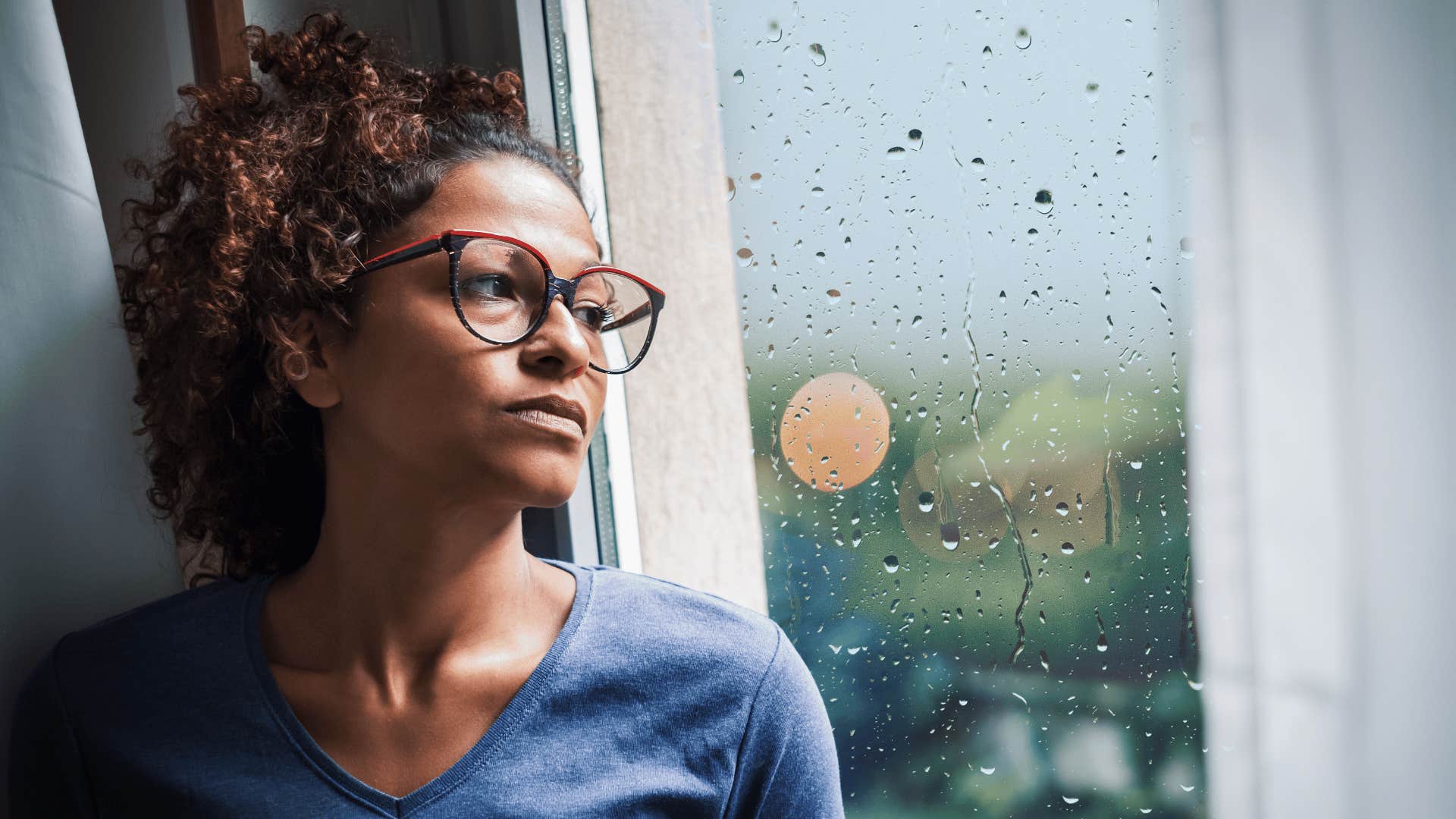 sad woman looking out window