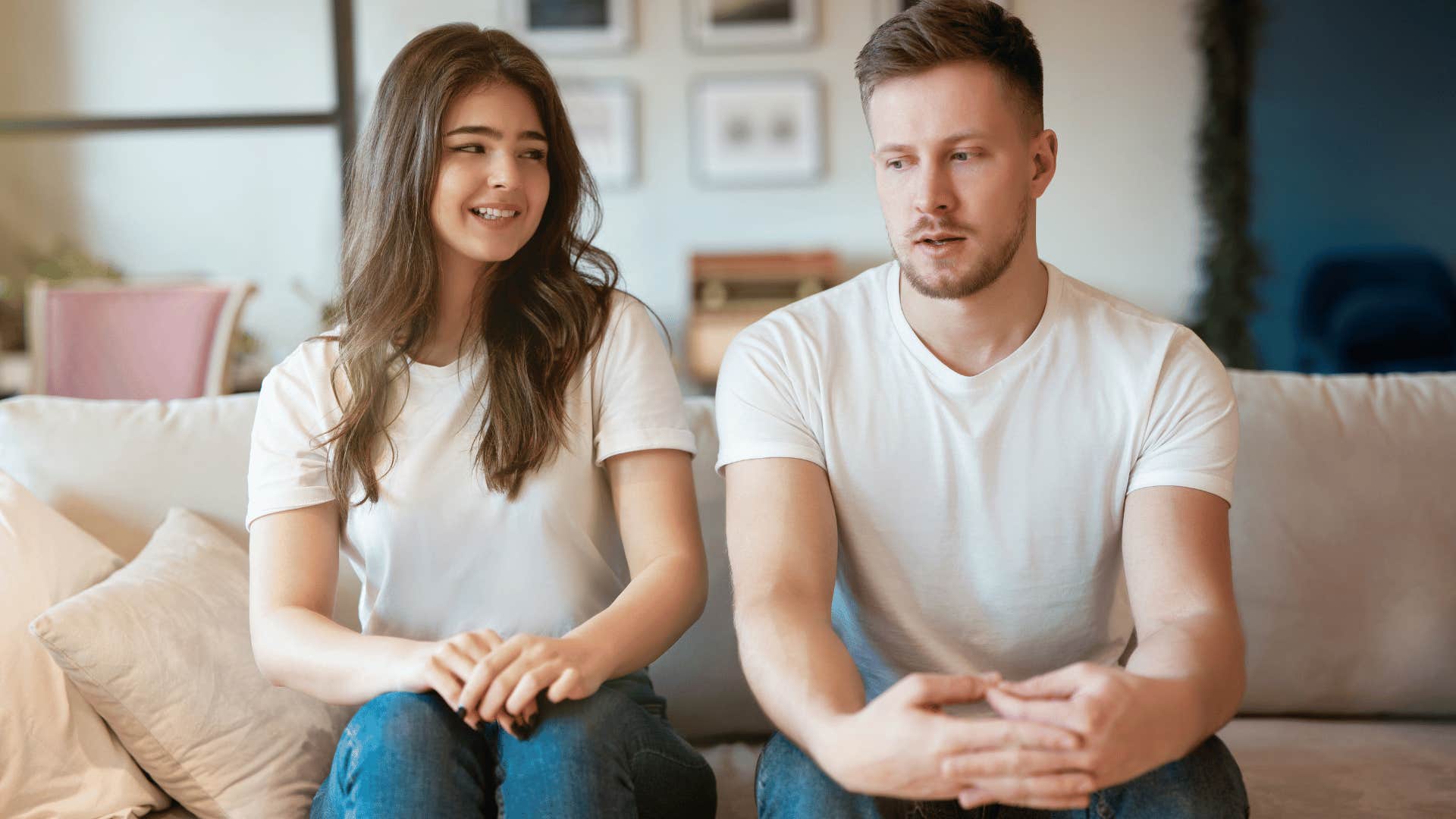 woman looking at man awkwardly while they both sit on couch