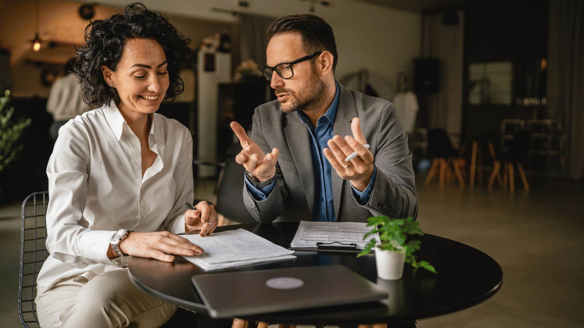 man explaining something to woman 