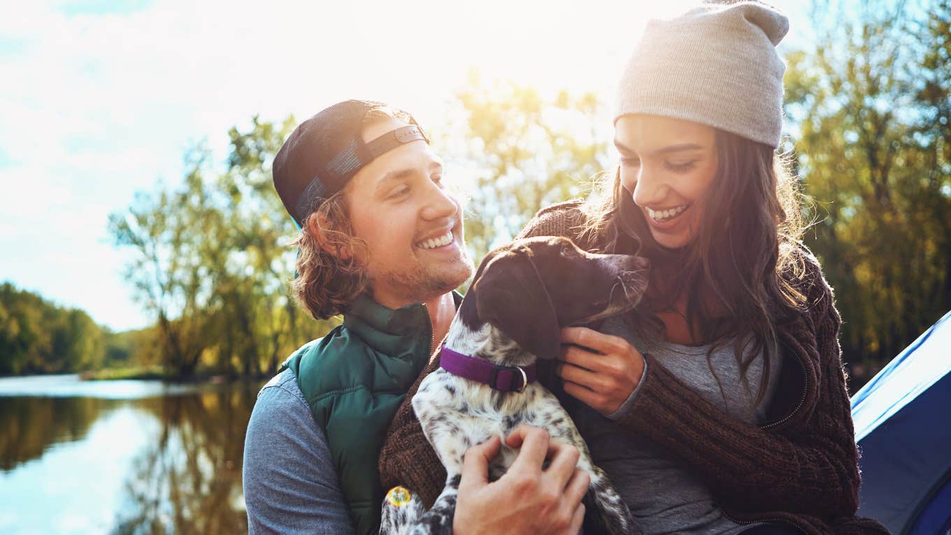 happy couple snugging their puppy