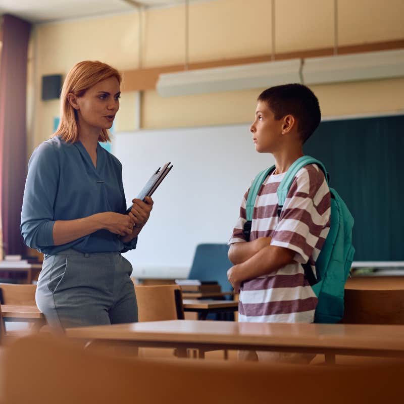 teacher talking to student in classroom