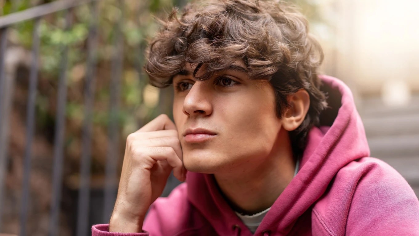 Teenage boy wearing a pink hoodie