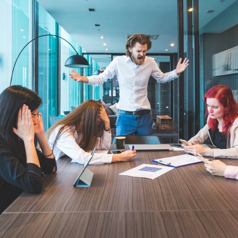 boss yelling at employees in conference room