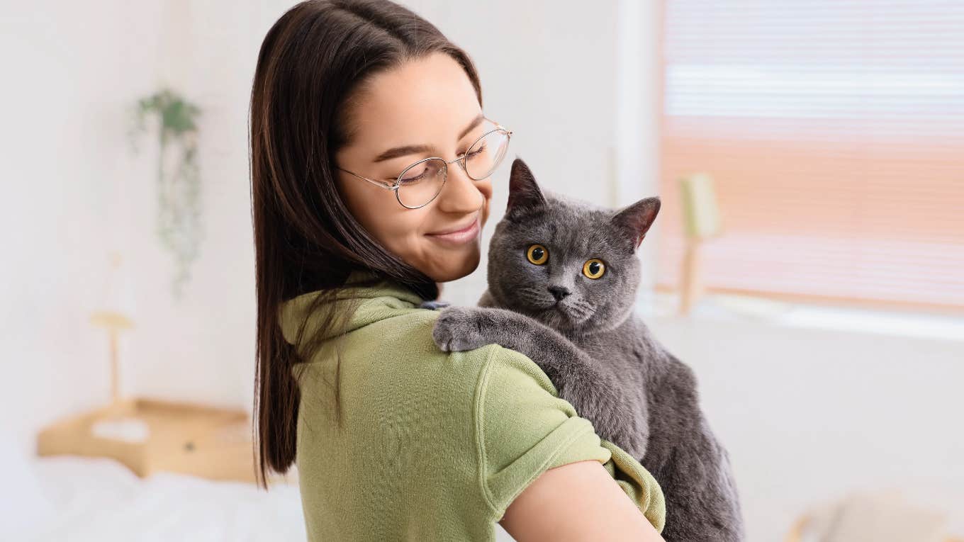 Animal communicator holding a grey cat. 