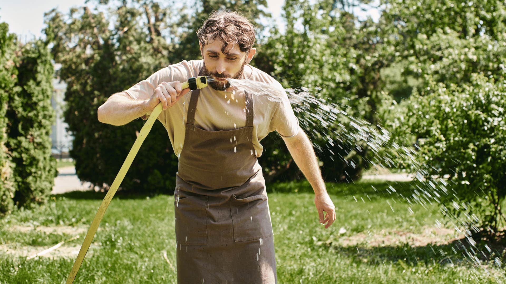 man drinking from hose