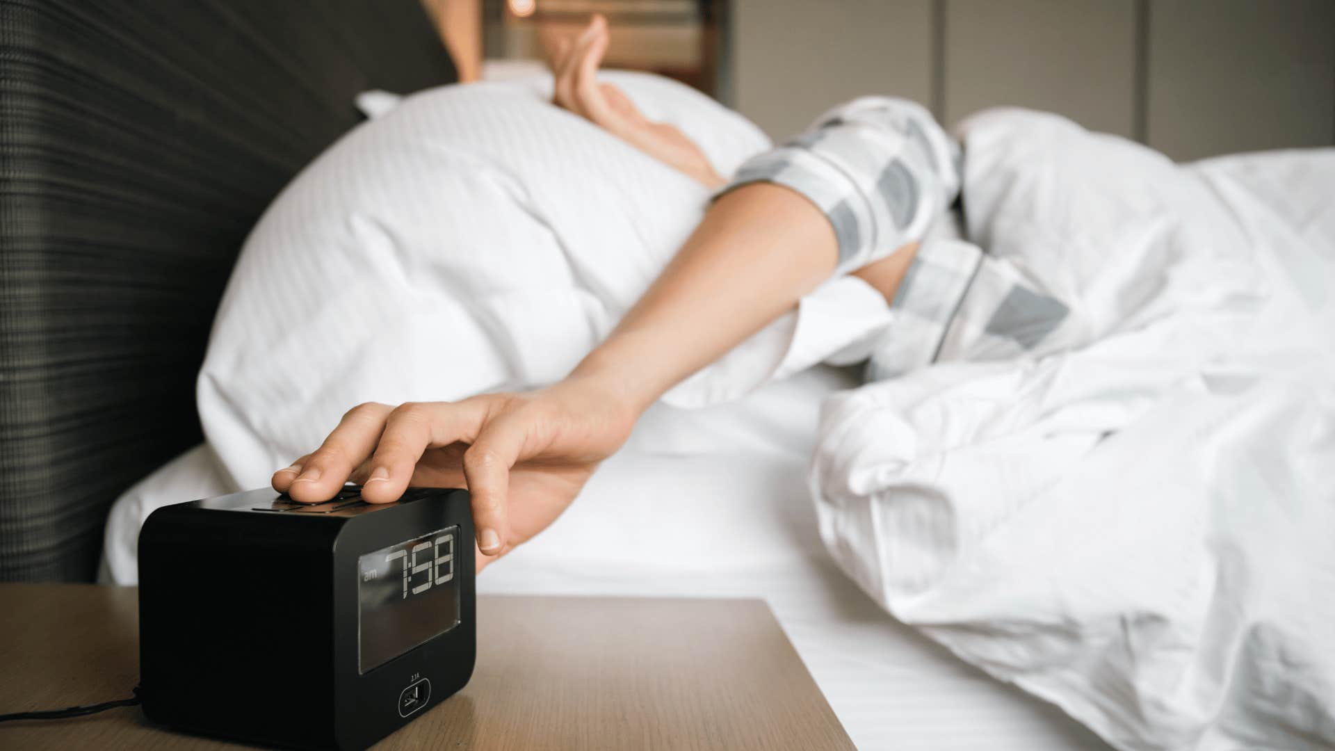 person pressing alarm clock button