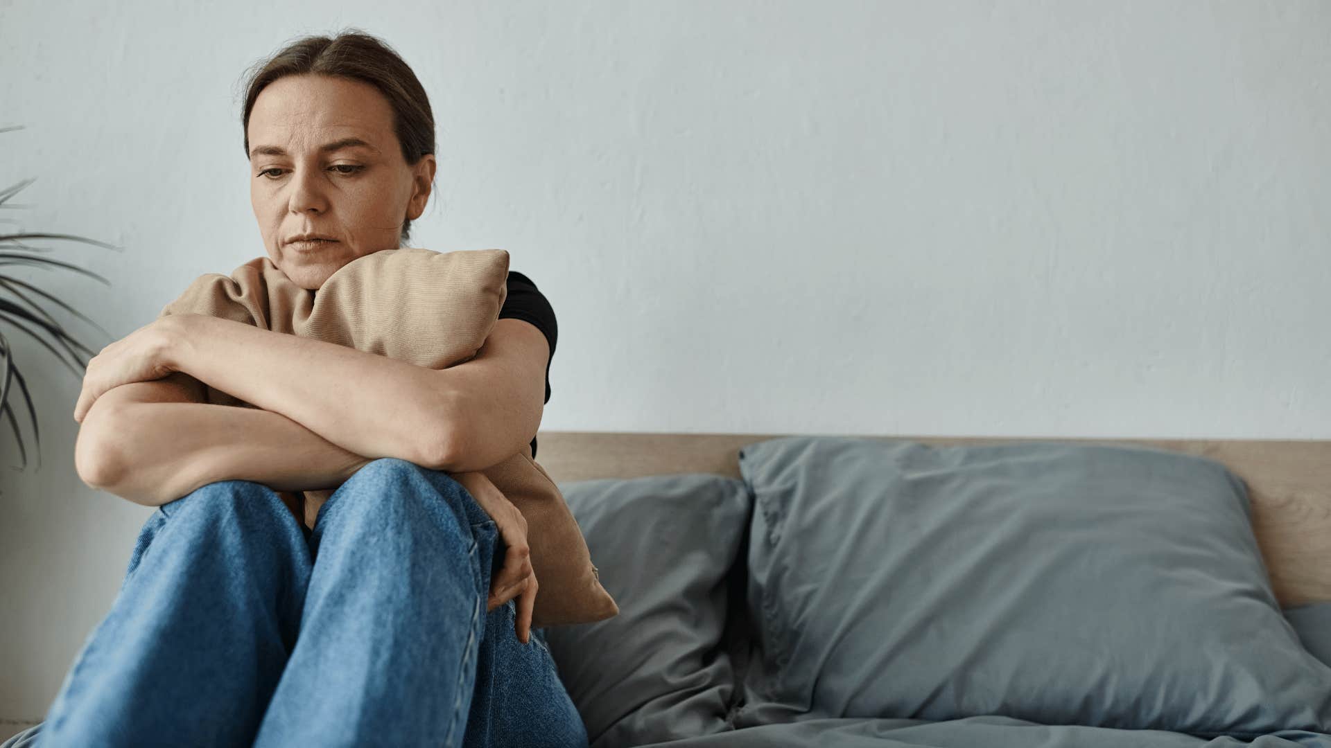 sad woman sitting on bed 