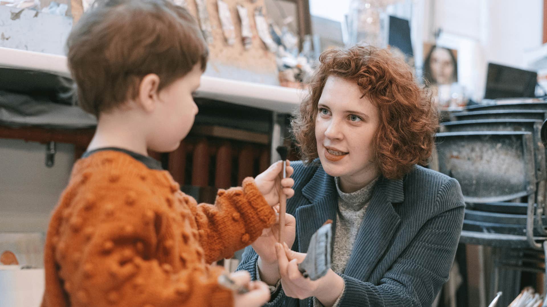 woman talking to preschool with paintbrush