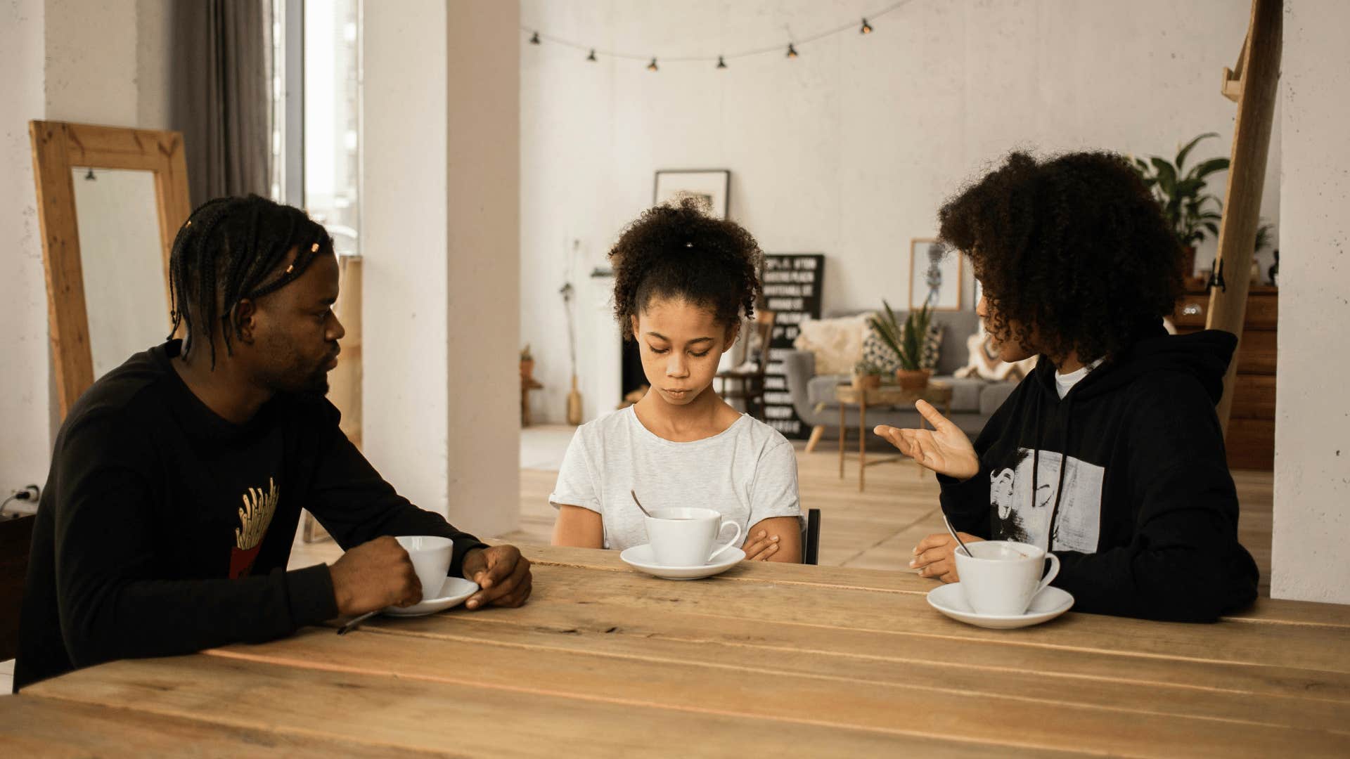 parents and upset child at a table