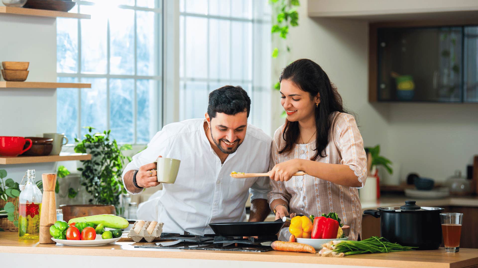 man helping woman cook