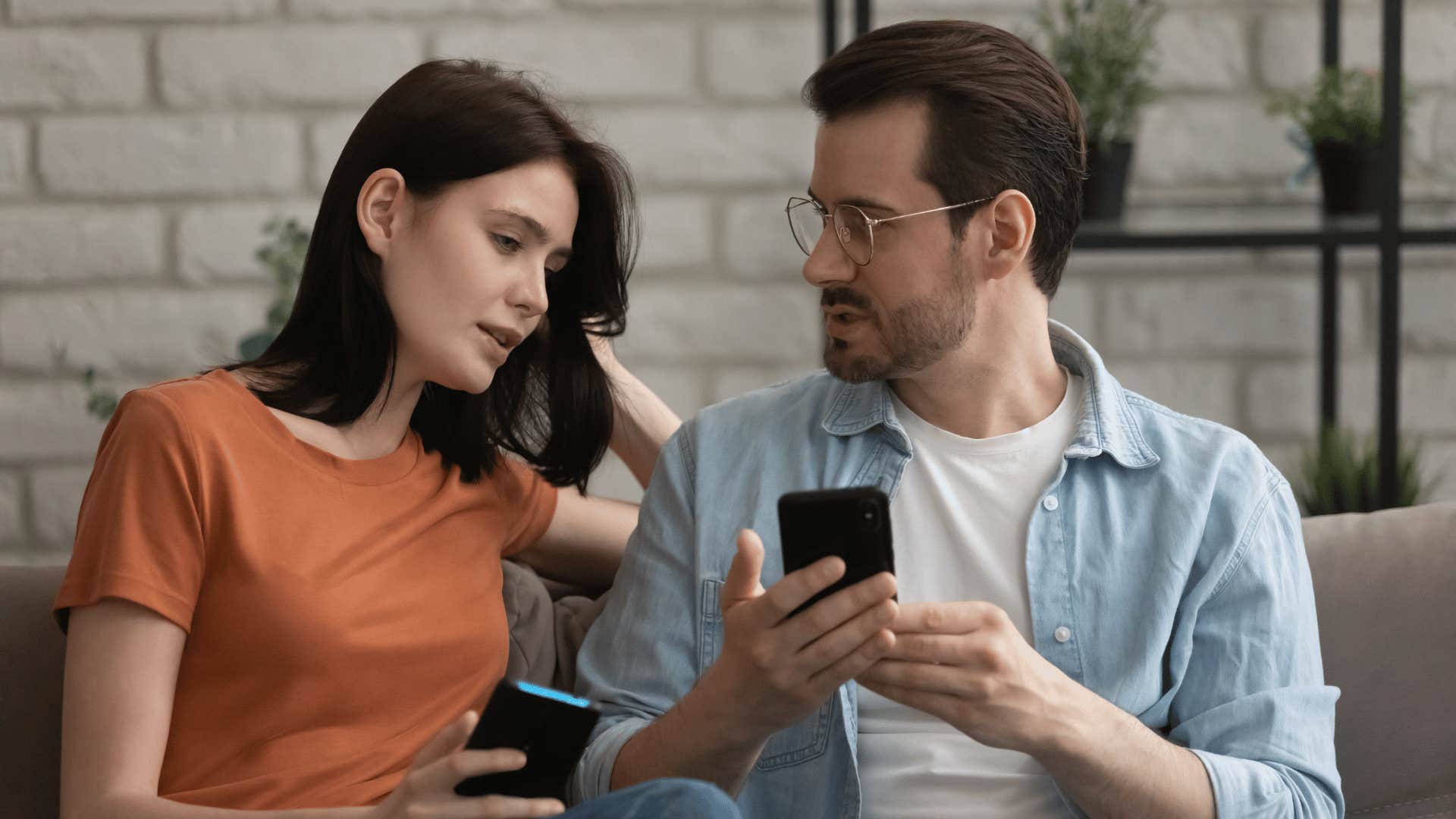 Couple compare information on phones, he looks upset