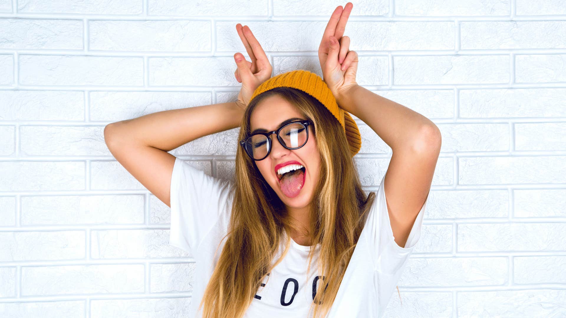 Fun woman makes silly face and uses her fingers for animal horns