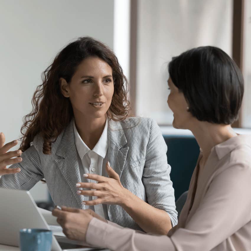 two business woman talking with an open laptop