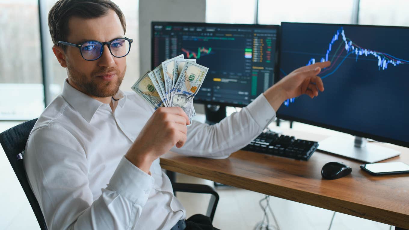 rich man holding money and pointing to computer projections