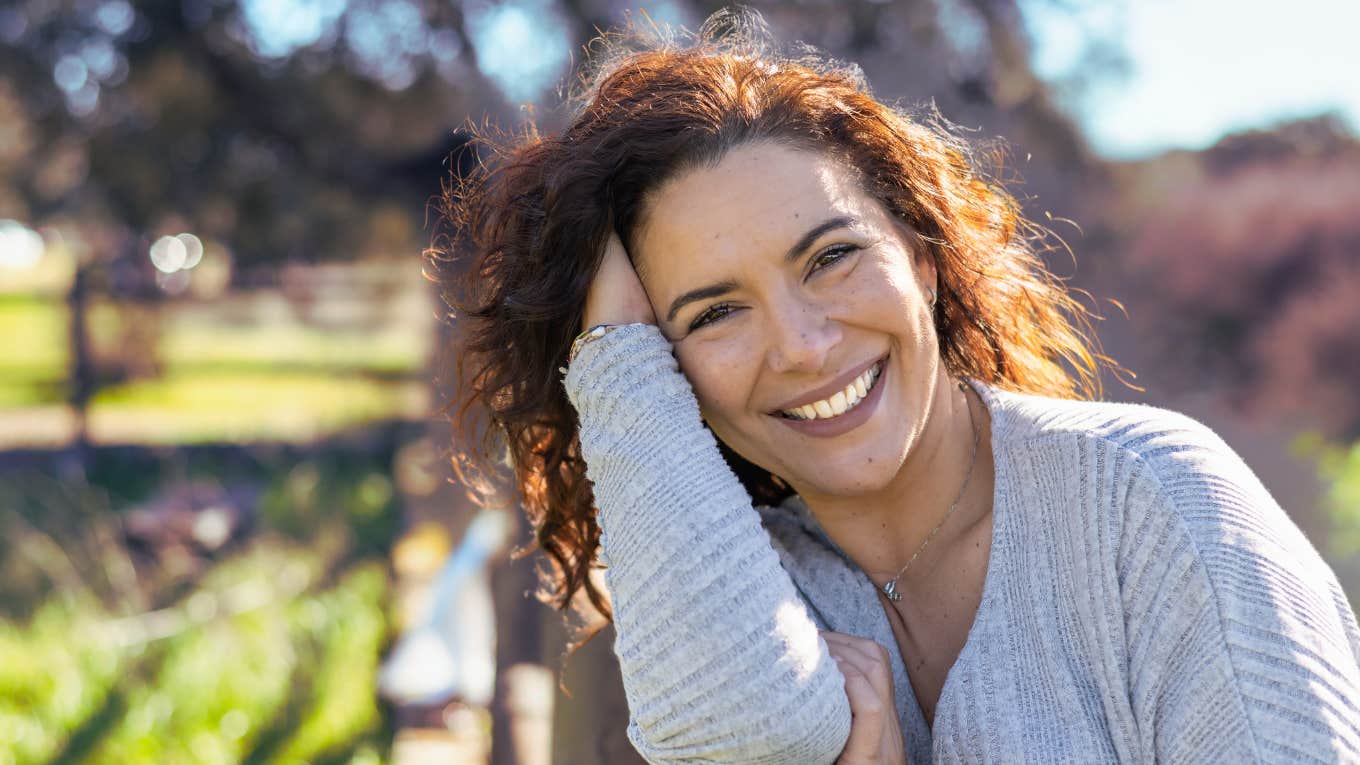 Happy woman outdoors doesn't realize she repels guys 