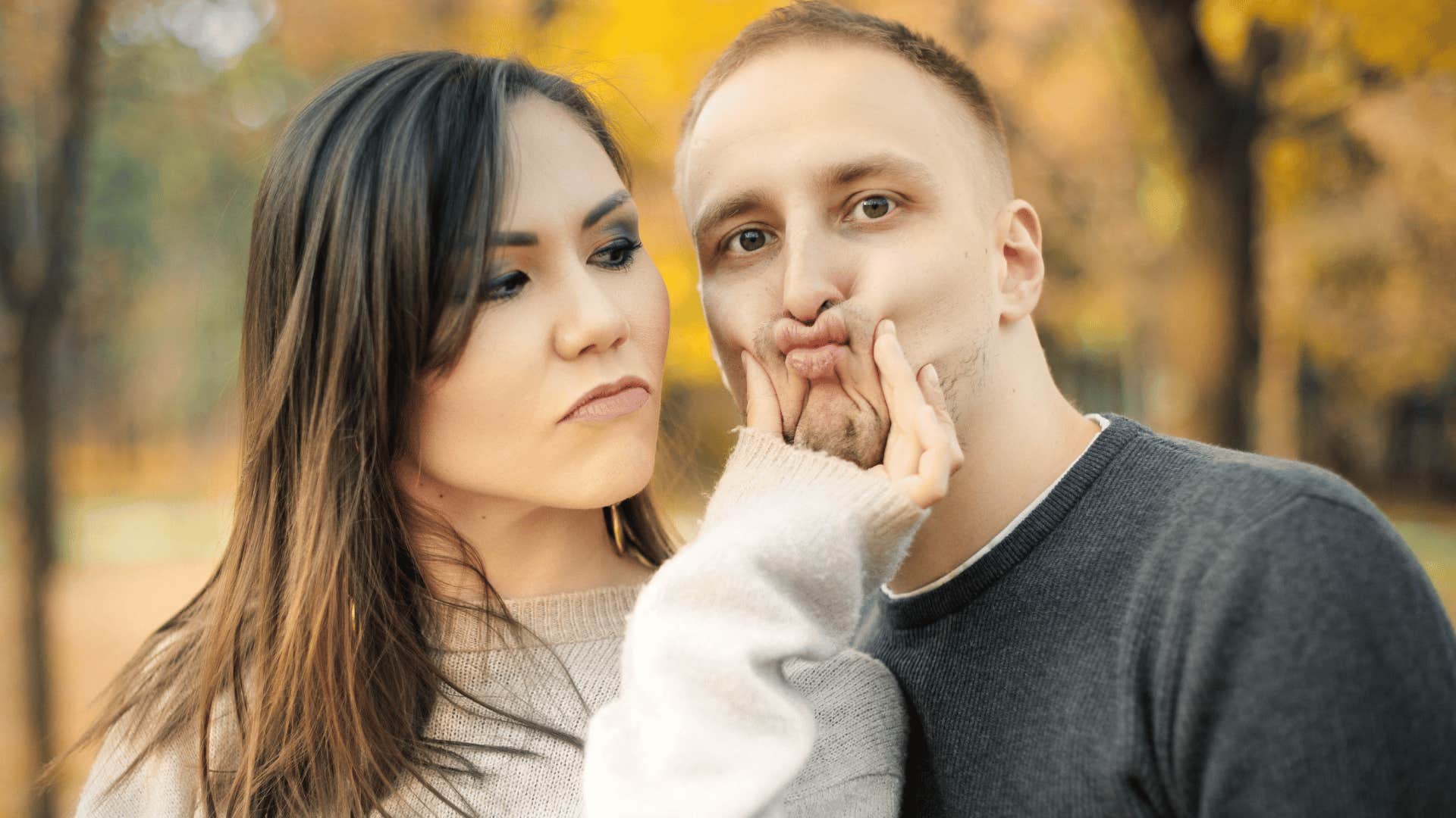 woman grabbing mans face and squishing it 