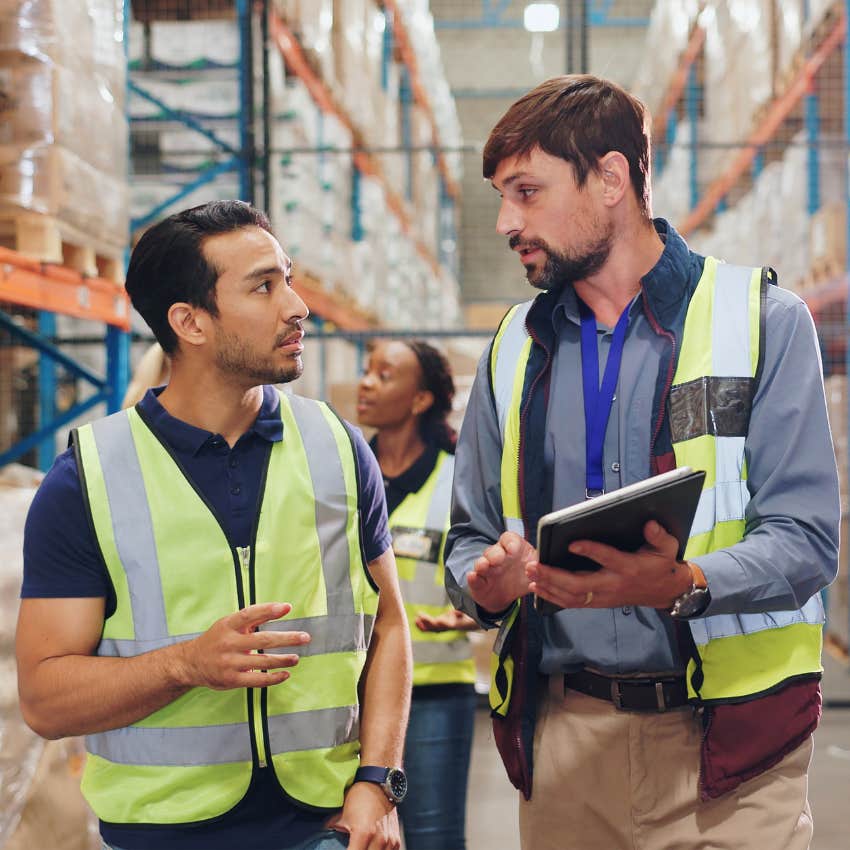 Warehouse workers talking to each other at their jobs. 