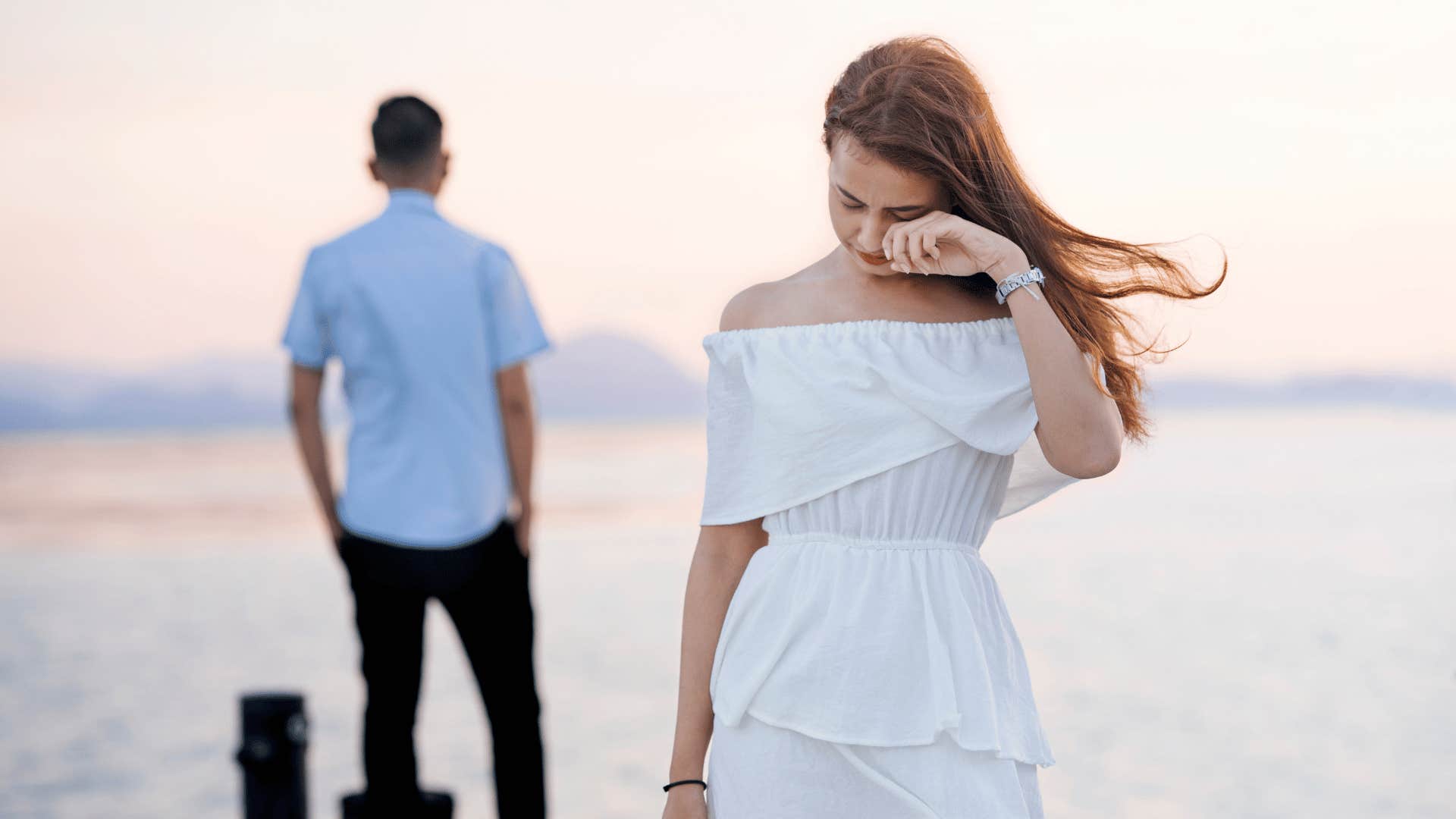 woman walking away tearfully from man