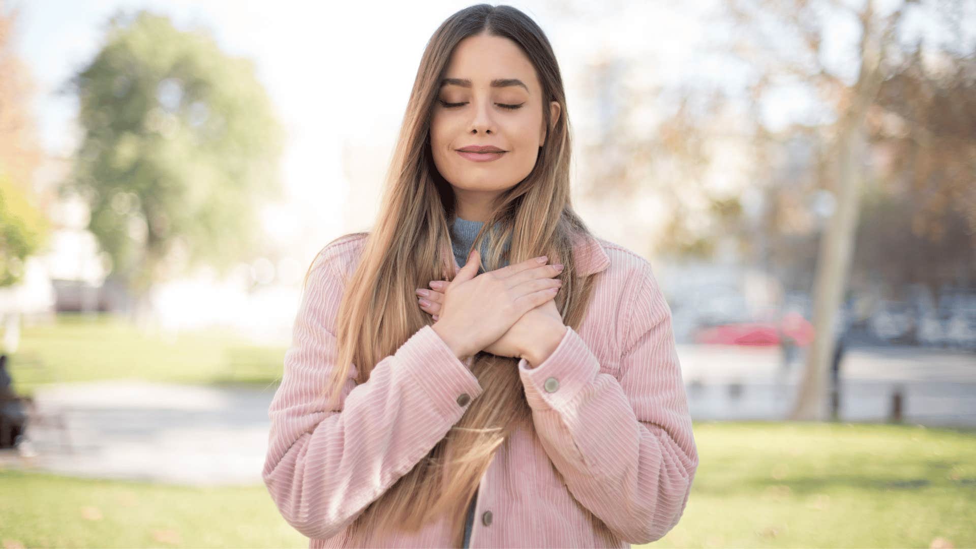 woman holding hand over heart