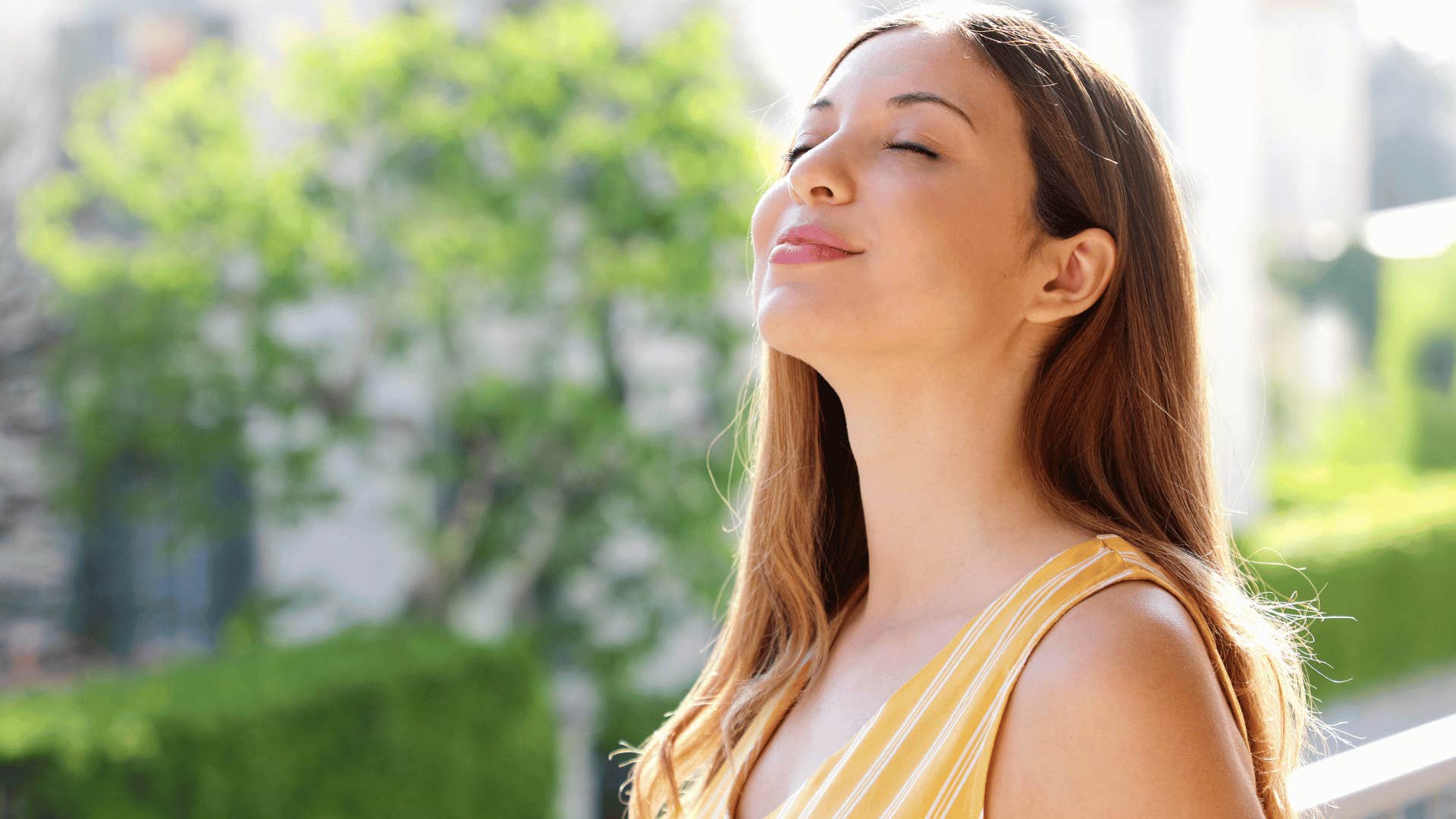 woman smiling while closing eyes