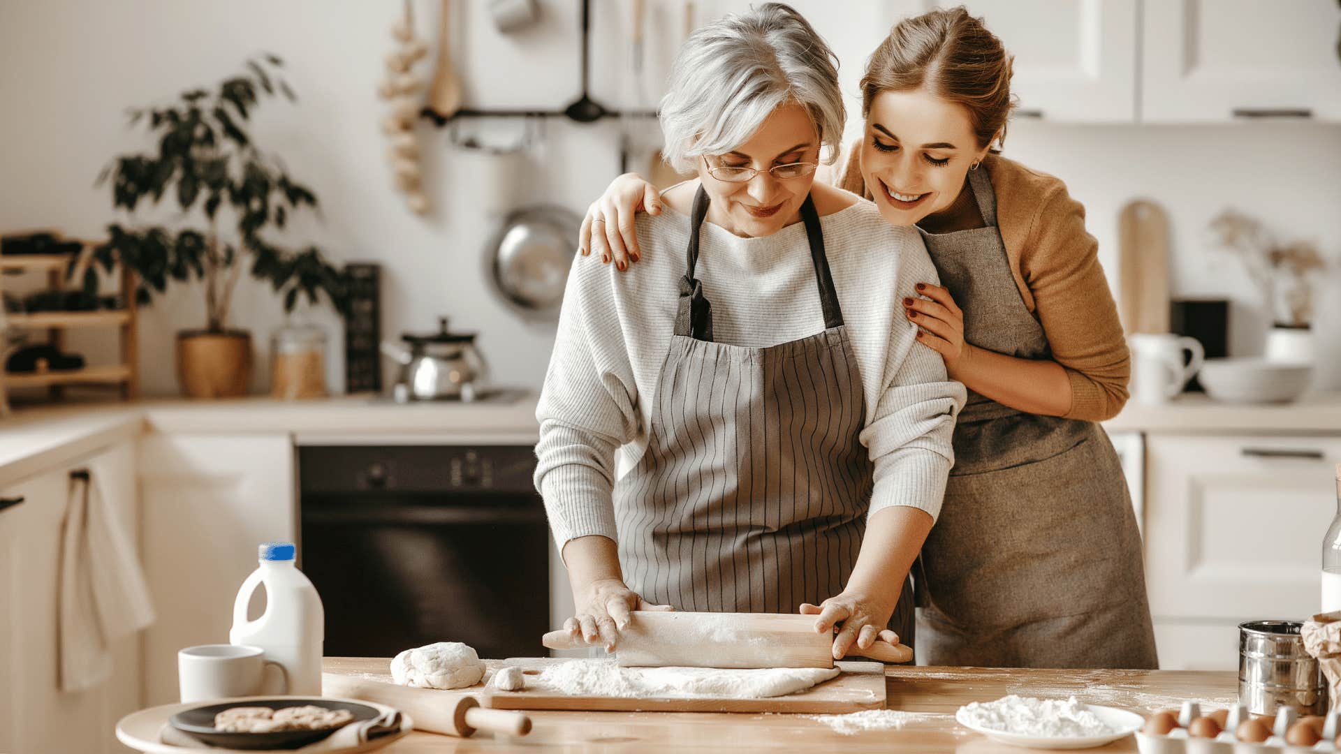 younger woman hugging older woman while they bake