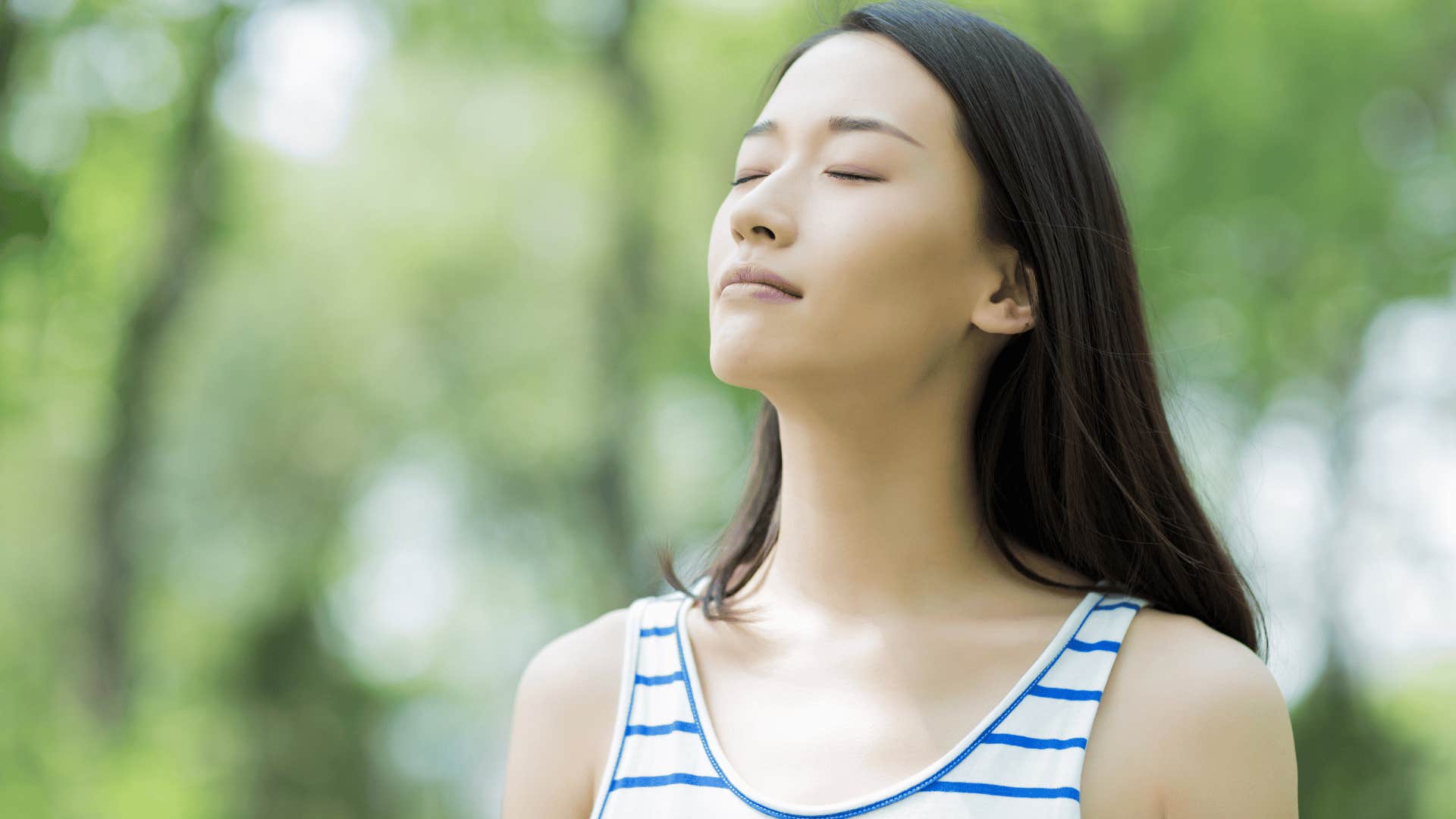 woman breathing in deep while she is outside 