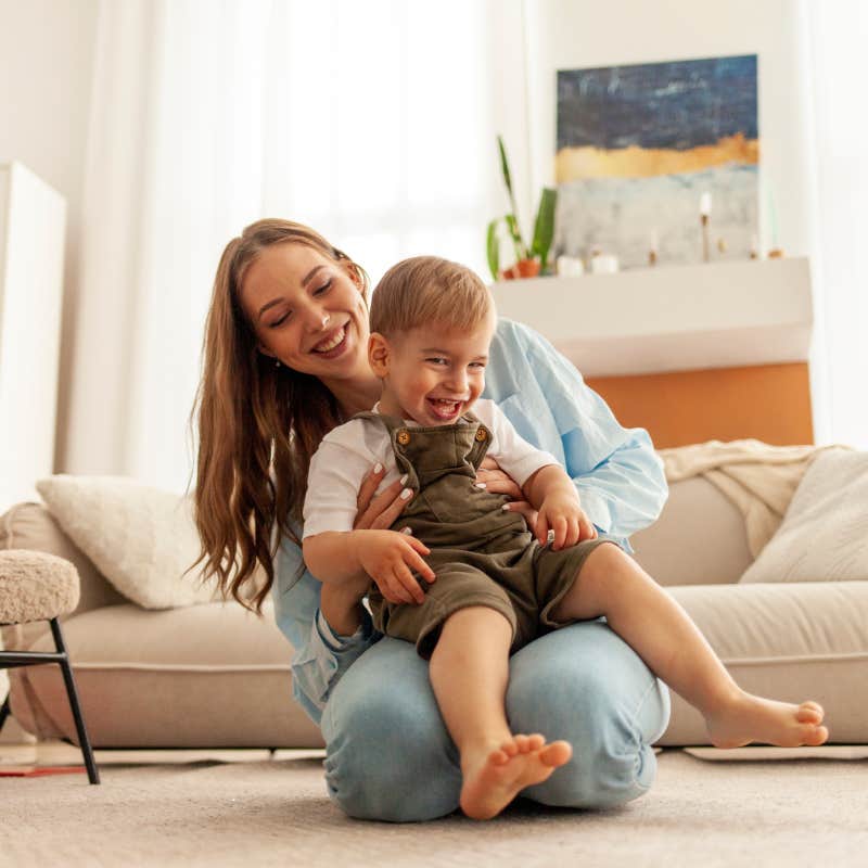 mom playing with young son on floor