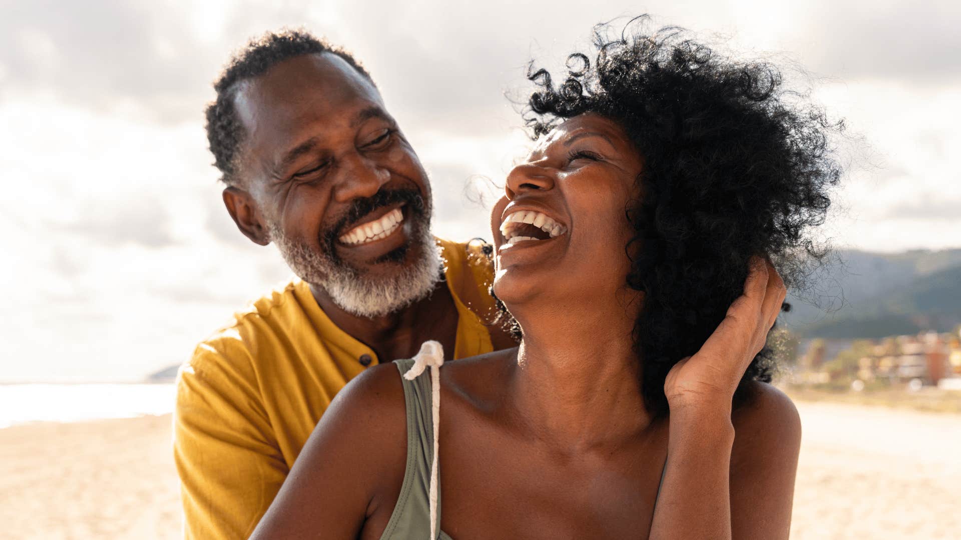 Couple laughs with arms around each other