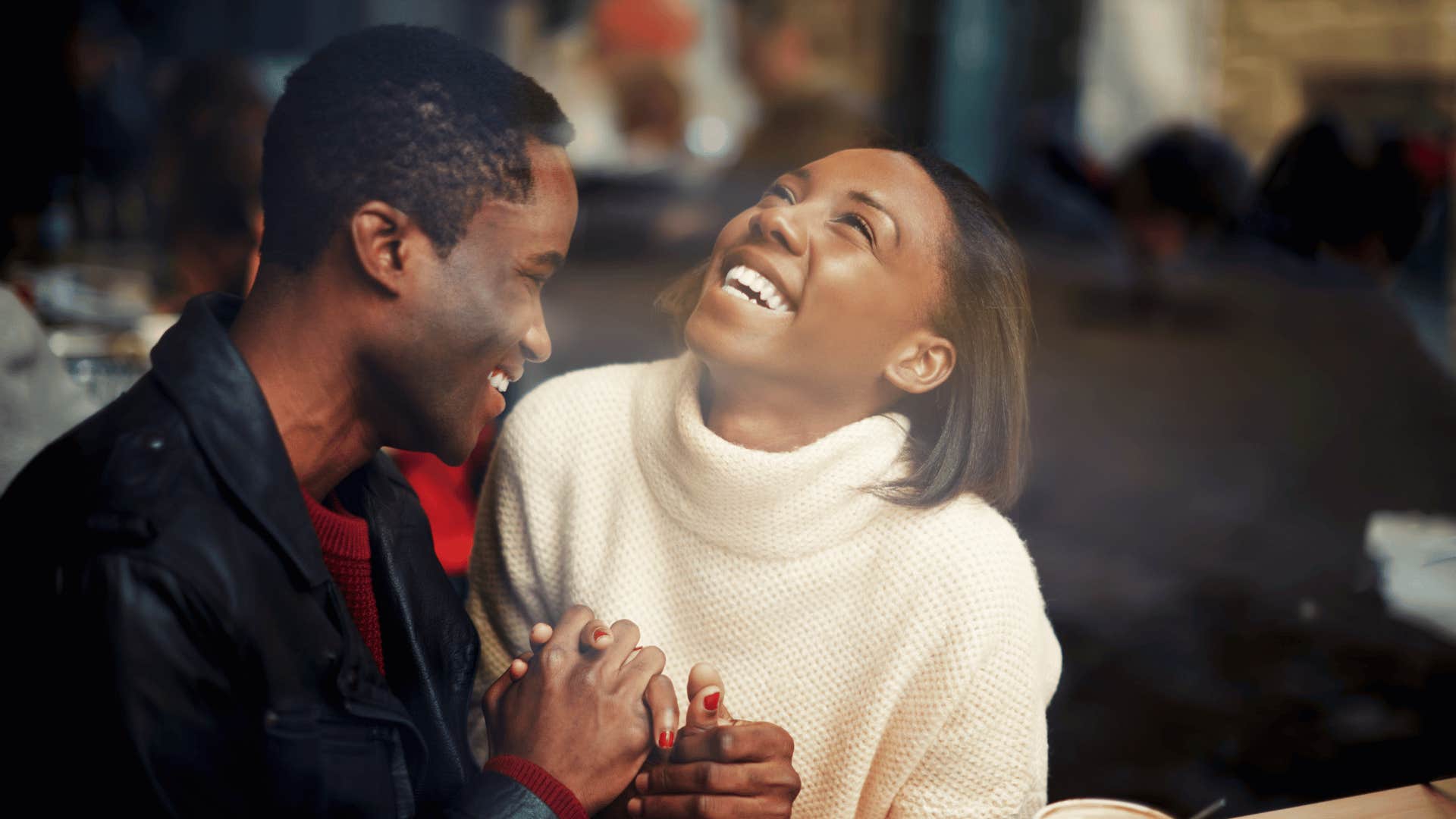 Man and woman hold hands and laugh