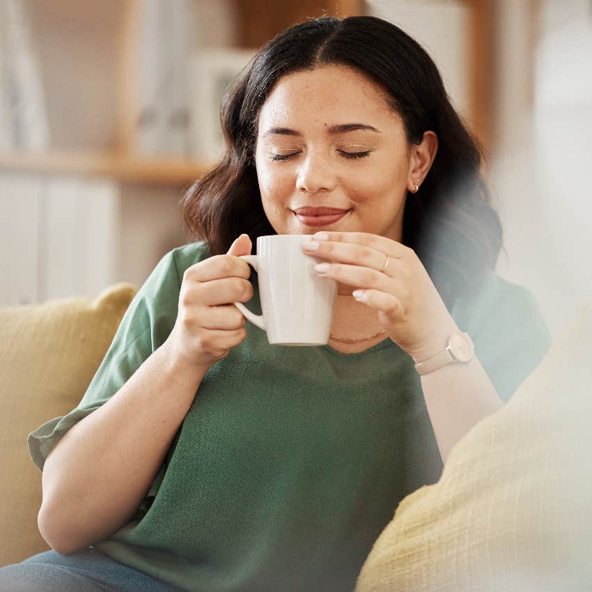 Joyful woman having her first sip of coffee in the morning