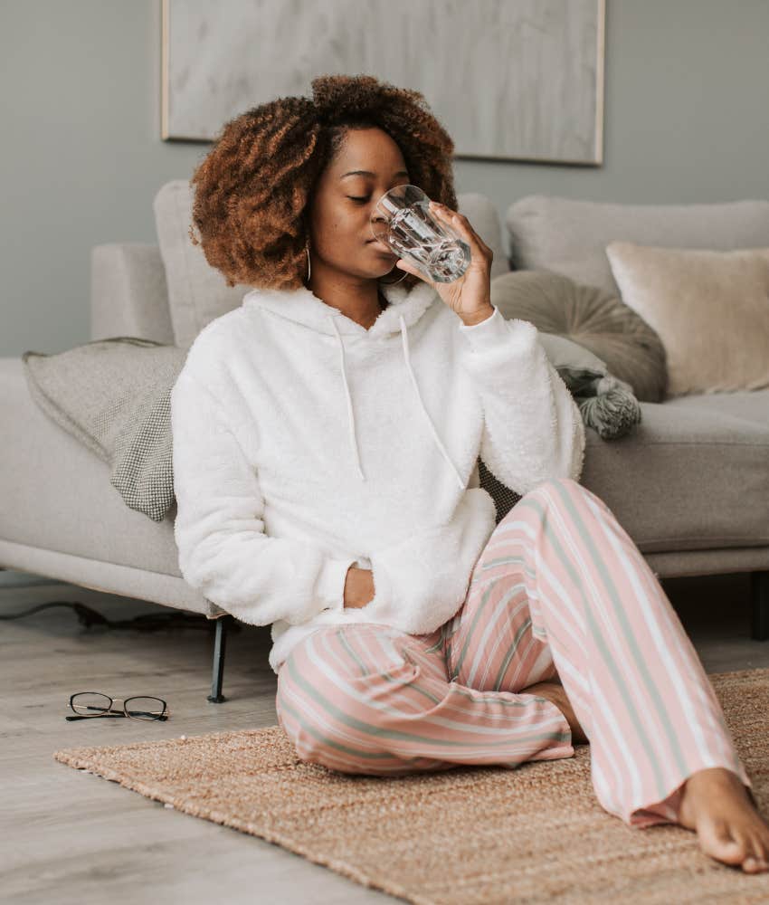 woman drinking a glass of water in her living room