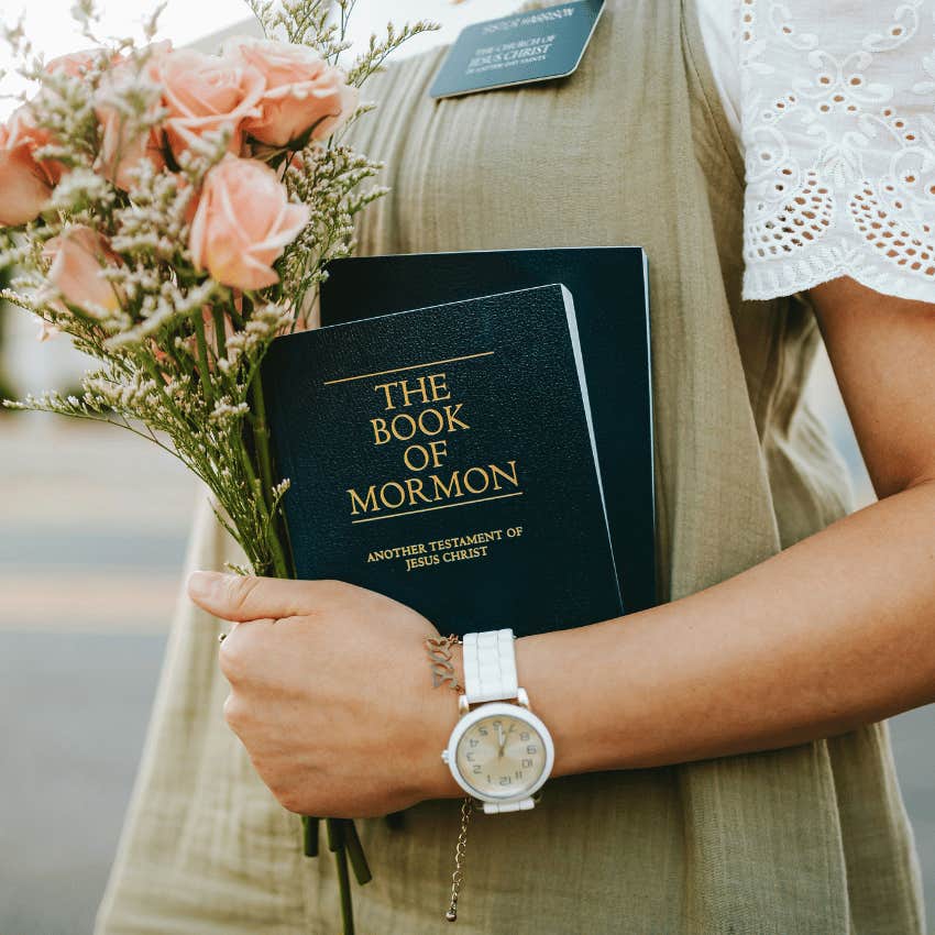 woman holding the book of mormon