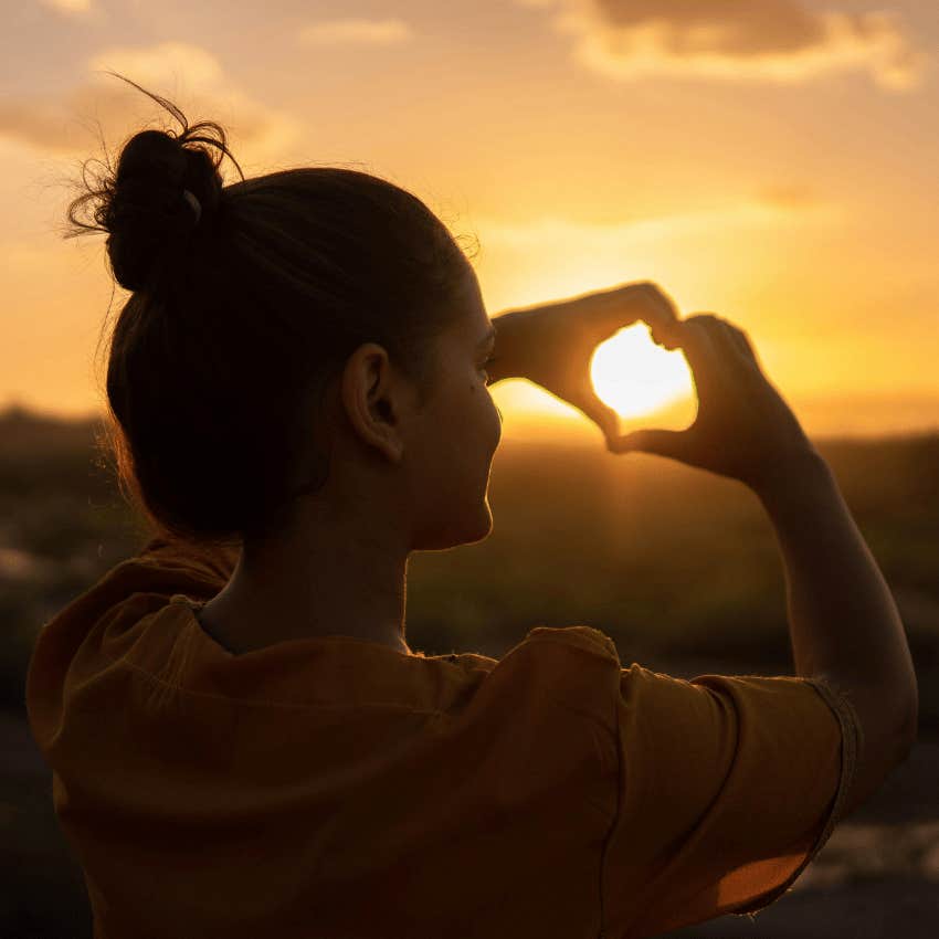 woman holding up hand heart