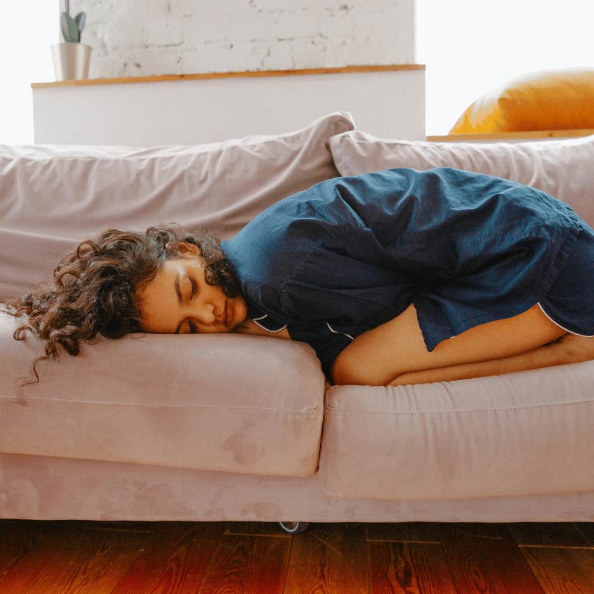 woman in pain curled into herself