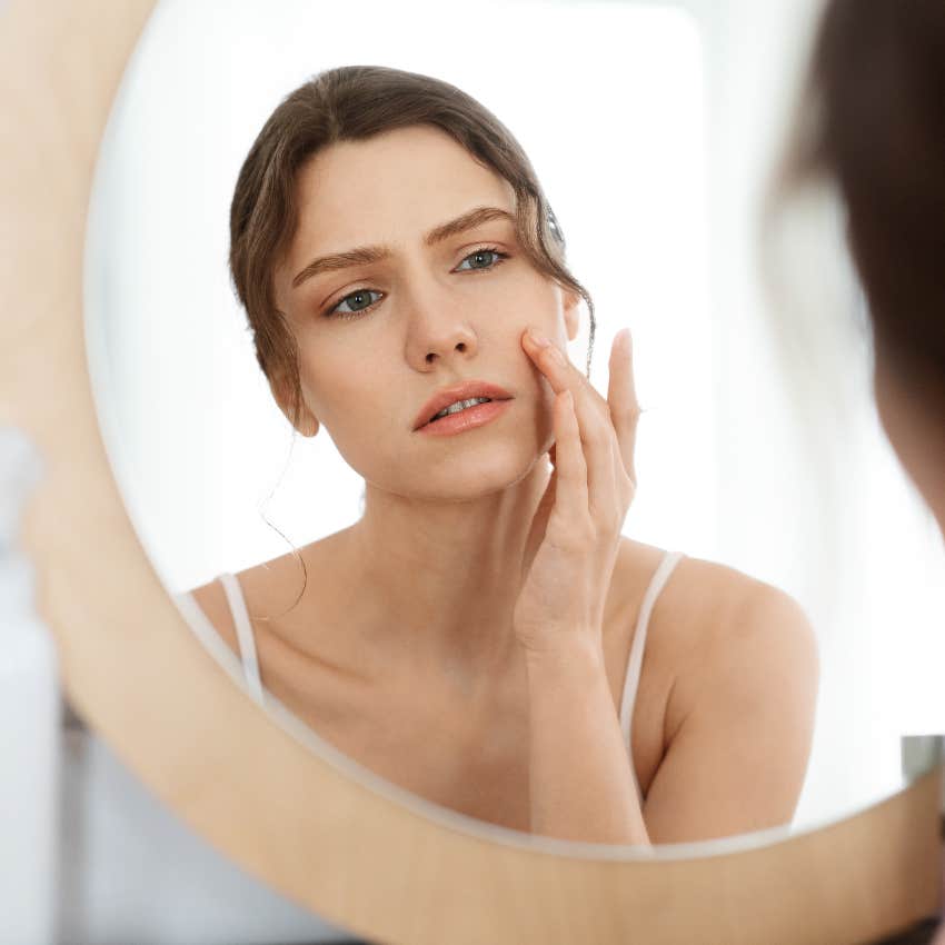 Unhappy woman looking in the mirror