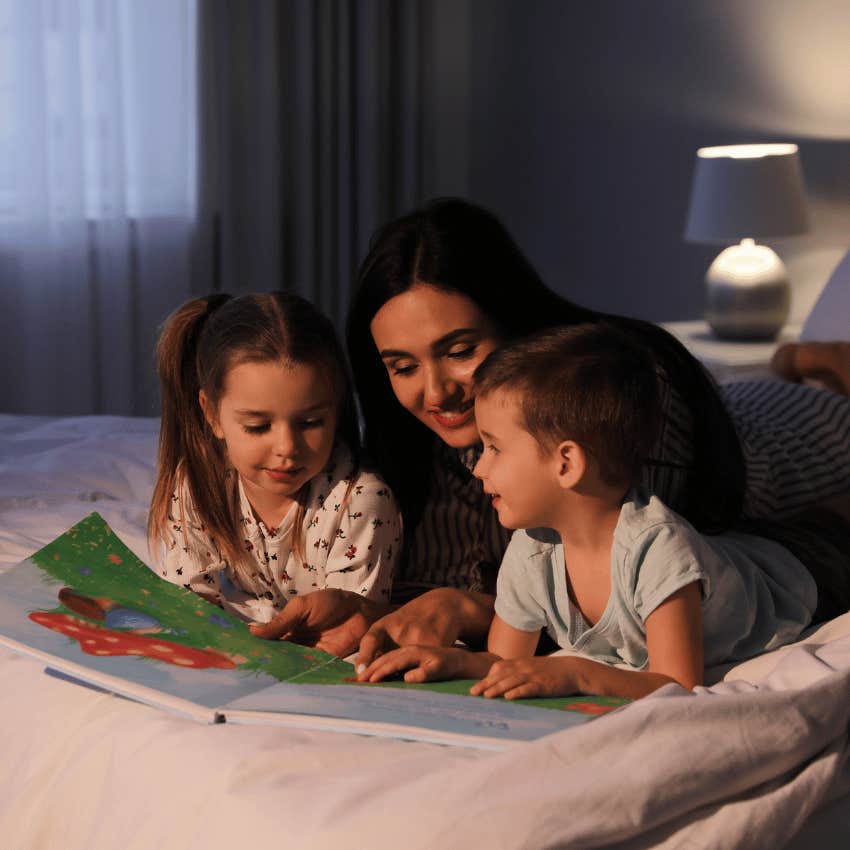 woman reading children's book with two kids