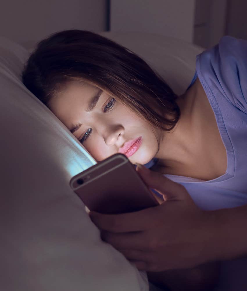 woman reading phone in bed