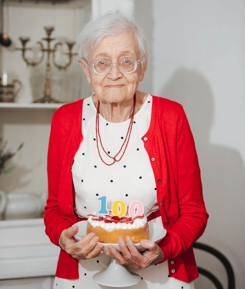 older woman holding birthday cake