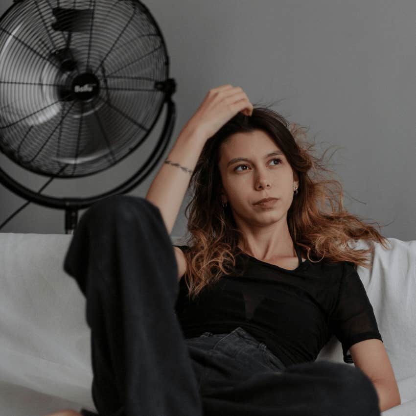 woman sitting in front of air fan