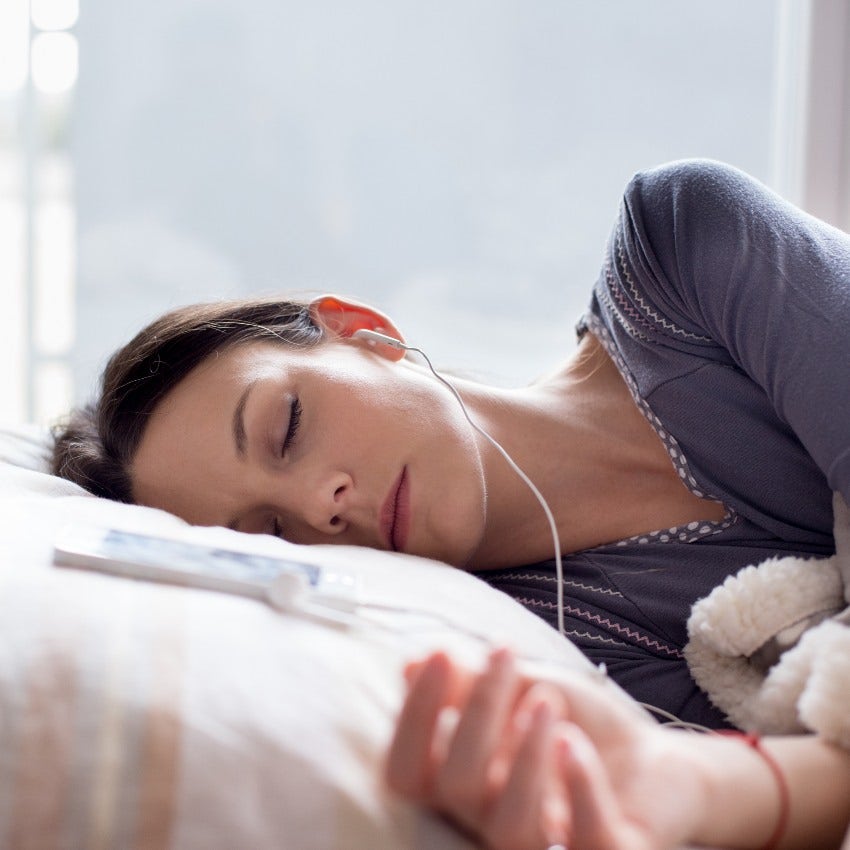 Woman wearing headphones to tune out neighbor's crying newborn baby